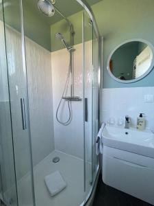 uma casa de banho com um chuveiro e um lavatório. em Captain's Lounge - Bungalow XL em Westerland