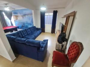 sala de estar con sofá azul y silla en Quartos centro de londrina Ar condicionado, en Londrina