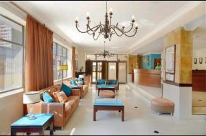 a living room with a couch and a chandelier at Cia’s Seaside Serenity @ Oceanic Unit 36 in Durban