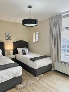 a bedroom with two beds and a window at Cia’s Seaside Serenity @ Oceanic Unit 36 in Durban