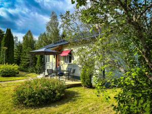 een klein huisje met een tafel en een paraplu bij Ferienhaus am Wald im Land der Elche in Torsby