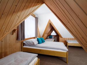 a bedroom with two beds in a attic at Pokoje Andrzej i Krystyna Lukaszczyk in Małe Ciche