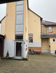 uma casa com uma porta e um banco à frente dela em Zimmer- Pension-Gästehaus em Meine