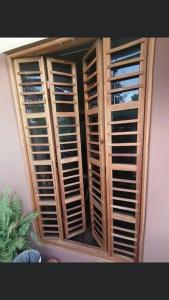 uma janela com persianas de madeira num quarto em Casa Guiba 2 Puerto Escondido em Puerto Escondido