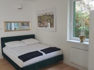 uma cama num quarto com uma janela em APARTAMENTY ZIELONY KAMELEON em Busko-Zdrój