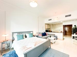 a bedroom with a large bed and a living room at Spacious Studio in Yas Island 113A1 in Abu Dhabi