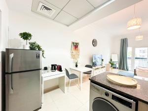 a kitchen and living room with a stainless steel refrigerator at Spacious Studio in Yas Island 113A1 in Abu Dhabi