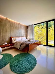 a bedroom with a bed and two green rugs at Escala83 Apartamentos in Mendoza