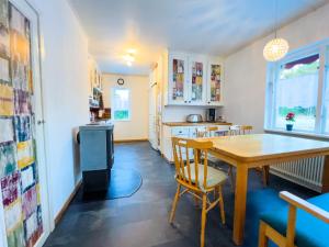 een keuken en eetkamer met een houten tafel en stoelen bij Ferienhaus am Wald im Land der Elche in Torsby