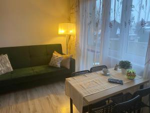 a living room with a green couch and a table at Apartament Piechoty Tanie spanie in Elblag