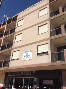 a building with a sign on the side of it at Apartamentos Vicent in Peñíscola