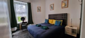 a bedroom with a large bed and a window at Sunrise at The Dens, 3 Rooms, 4 Beds, 2 Bathrooms, Fully Equipped, Wifi, Parking, Contractors Accommodation, Trade Favourite, Long Stays Rates Available by Sunrise Short Lets Dundee in Dundee