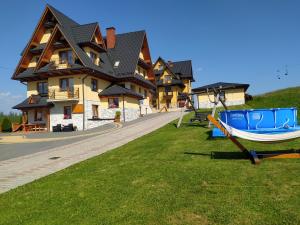 a house with a boat on the grass in front of it at Pokoje Andrzej i Krystyna Lukaszczyk in Małe Ciche