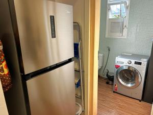een keuken met een roestvrijstalen koelkast en een wasmachine bij Hostel Pluto in Rio de Janeiro