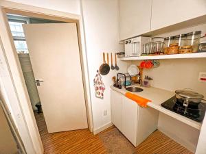 een kleine keuken met een wastafel en een fornuis bij Hostel Pluto in Rio de Janeiro