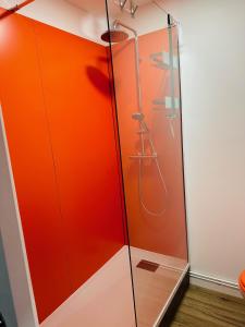 a shower stall with an orange wall at ORANGE APPART in Tourcoing