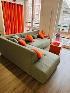 two green couches in a living room with orange pillows at ORANGE APPART in Tourcoing