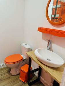 an orange bathroom with a toilet and a sink at ORANGE APPART in Tourcoing