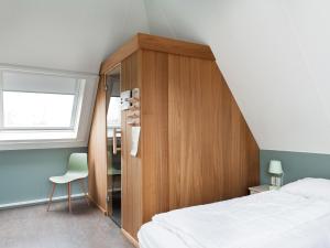 sypialnia z drewnianą szafką i łóżkiem w obiekcie Amazing holiday home in Friesland with Sauna and outdoor Spa w mieście Earnewâld