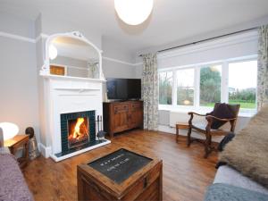 a living room with a fireplace and a couch at 3 Bed in Studland DC071 in Studland