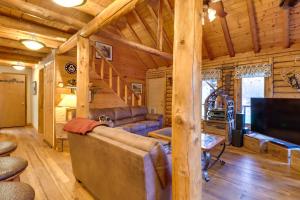 una sala de estar con sofá y TV en una cabaña de madera en Secluded, Pet-Friendly Cresco Log Cabin Fire Pit!, en Cresco