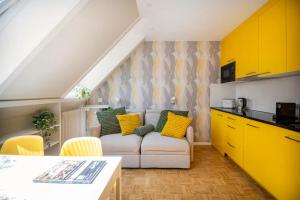 a living room with a couch and yellow cabinets at bedinBERN Aparthotel - Self Check-In in Bern