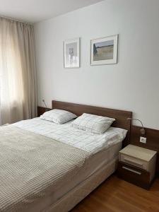 um quarto com uma cama grande e lençóis brancos em Belvedere Holiday Club Private Apartment em Bansko