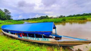 Mazán的住宿－ARAPARI AMAZON LODGE，一条河上带有蓝色屋顶的船