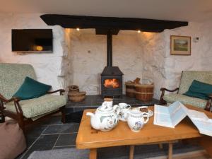 a living room with a fireplace and a table with tea pots at 3 Bed in Arthog 66579 in Arthog