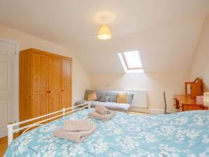 a bedroom with a blue bed with towels on it at 1 Bed in Bala 89369 in Llandderfel