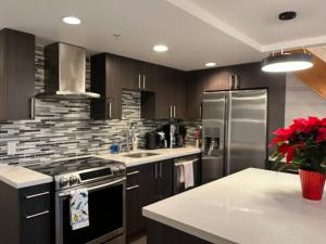 cocina con nevera de acero inoxidable y encimera en Modern top-floor 1-bedroom loft with free parking en Vancouver