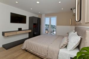 a bedroom with a large bed and a television at Villa Milton Luxe Hvar in Hvar
