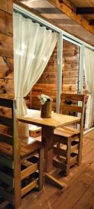 una mesa de madera y sillas en una habitación con ventana en Glamping Isaju , Santa Helena , Valle del Cauca, en El Cerrito