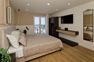 a bedroom with a large bed and a television at Villa Milton Luxe Hvar in Hvar +35 photos