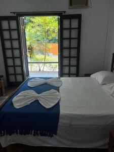 A bed or beds in a room at Pousada Aquarela Maresias