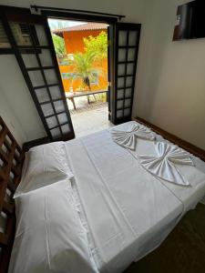 Een bed of bedden in een kamer bij Pousada Aquarela Maresias