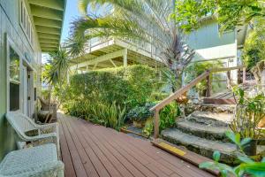a house with a wooden deck with stairs and plants at Inviting Aiea Bungalow with Balcony, Grill and Views! in Aiea
