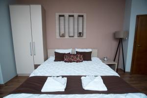 um quarto com uma grande cama branca e 2 almofadas em Villa La Munte em Kruševo