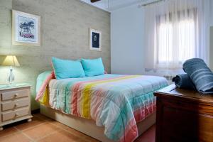 LuqueにあるCasa Rural Vistaverdeのベッドルーム1室(カラフルな掛け布団付きのベッド1台付) +19枚の写真