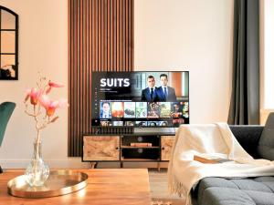 een woonkamer met een flatscreen-tv bij Fynbos Apartments Deluxe, Balkon, Netflix, Parkplatz in Meißen
