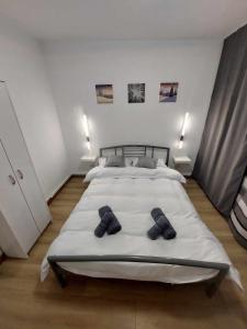 a bedroom with a large bed with two slippers on it at Olive Apartment in Lupeni