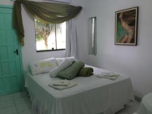 ein Schlafzimmer mit einem Bett mit zwei Handtüchern darauf in der Unterkunft Hotel Pousada Reimar in Balneário Camboriú