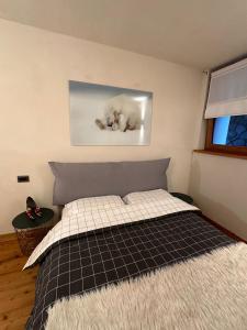 a bedroom with a bed with a picture on the wall at MB26 in Courmayeur