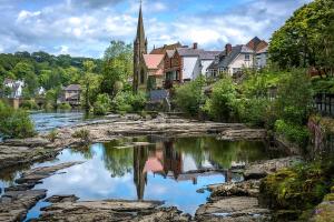 a small town with a river and a church at Fern Studio 1 Bedroom Apartment in Llangollen