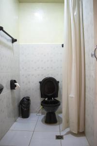 e bagno con doccia e servizi igienici neri. di Ima Sumaj Hostel a Copacabana