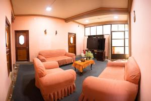 sala de estar con muebles de color naranja y TV en Ima Sumaj Hostel en Copacabana