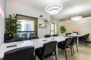 une salle de réunion avec des tables et des chaises dans un bureau dans l'établissement Berloga Capsule JBR, à Dubaï