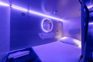 una camera con letto bianco e specchio di Berloga Capsule JBR a Dubai