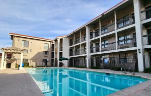 a swimming pool in front of a apartment building at La Quinta Inn by Wyndham Fresno Yosemite in Fresno