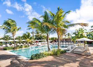 - une piscine avec des chaises longues et des palmiers dans l'établissement Hodges Bay Resort & Spa, à Saint Johnʼs